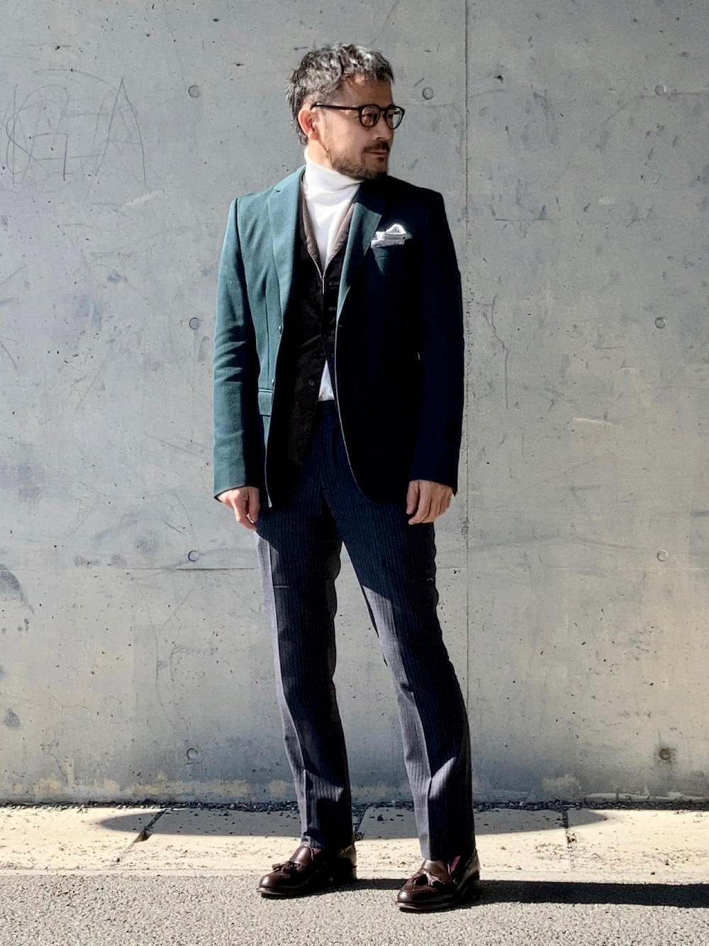 ホワイト系のニット/セーター、グリーン系のテーラードジャケット、グレー系のスラックスを着用したメンズの冬コーディネートの1枚目の写真