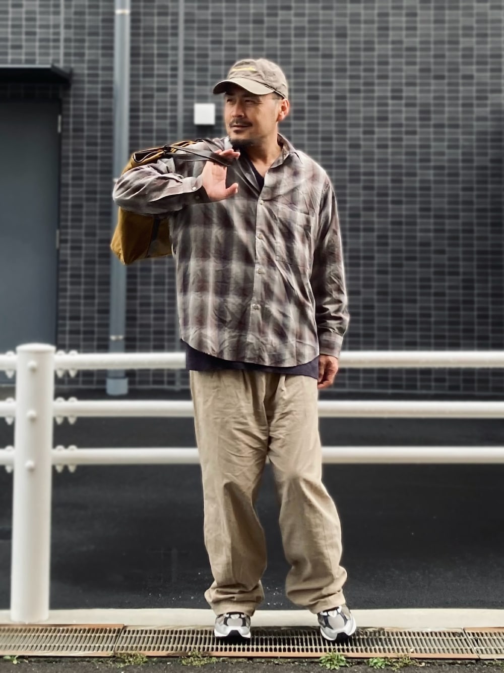 ベージュ系のシャツ/ブラウス、ベージュ系のスラックス、ブラック系のスニーカーを着用したメンズの春コーディネートの1枚目の写真