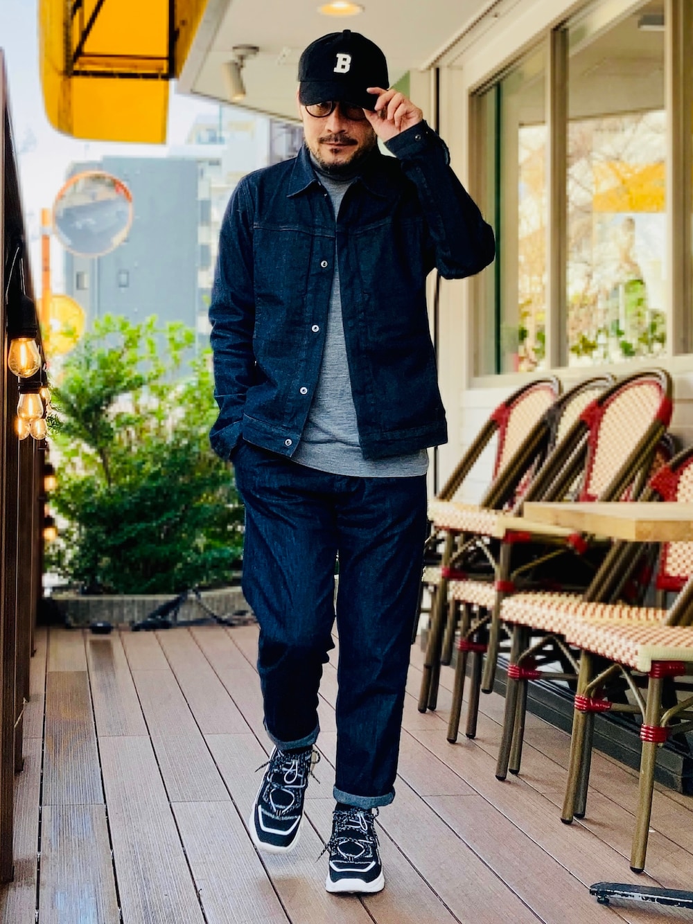 グレー系のニット/セーター、ブルー系のデニムジャケット、ブルー系のデニムパンツを着用したメンズの春コーディネートの1枚目の写真