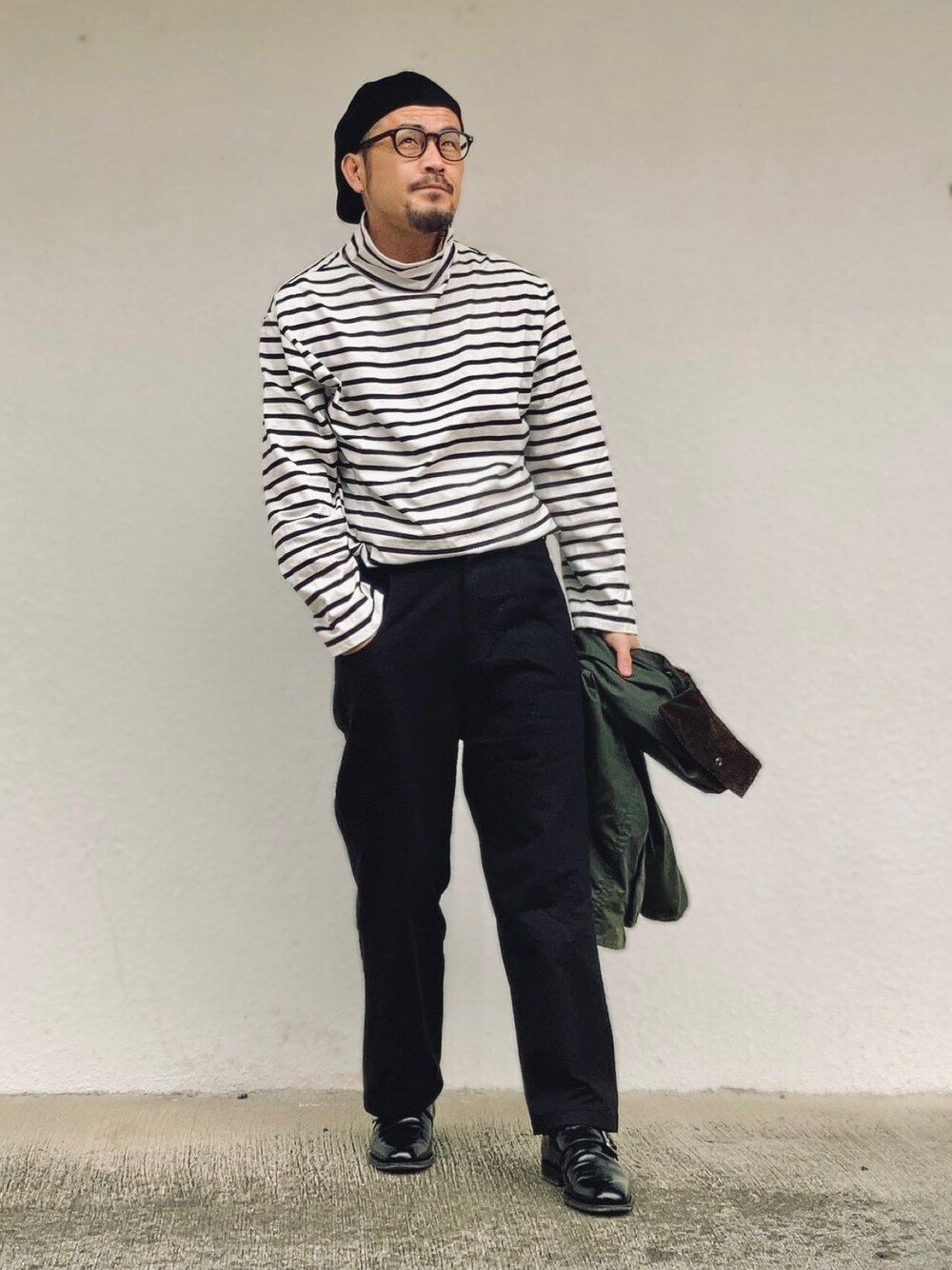 ブラック系のTシャツ/カットソー、グリーン系のその他アウター、ブラック系のパンツを着用したメンズの春コーディネートの1枚目の写真
