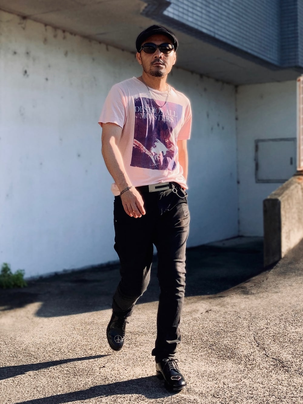 ピンク系のTシャツ/カットソー、ブラック系のデニムパンツ、ブラック系のドレスシューズを着用したメンズの夏コーディネートの1枚目の写真