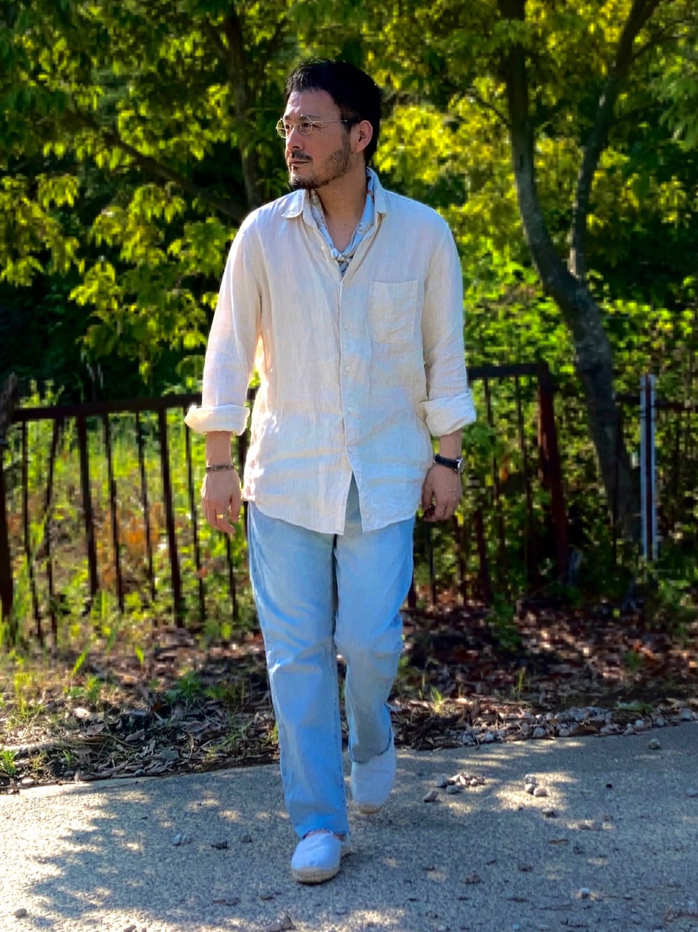 ベージュ系のシャツ/ブラウス、ブルー系のデニムパンツ、ホワイト系のスリッポンを着用したメンズの夏コーディネートの1枚目の写真