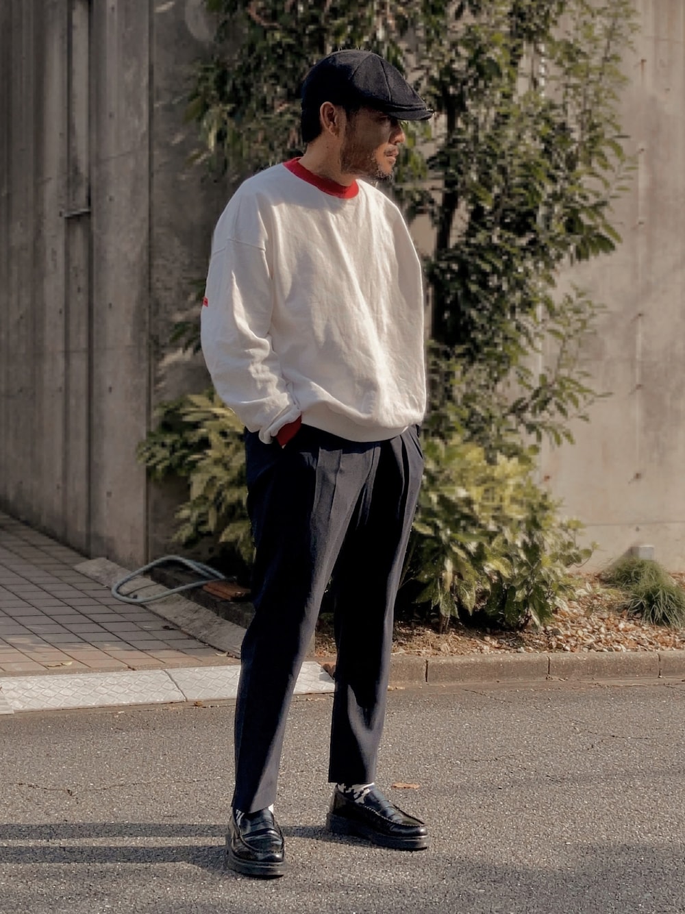 ホワイト系のスウェット、ブルー系のスラックス、ブラック系のローファーを着用したメンズの秋コーディネートの1枚目の写真