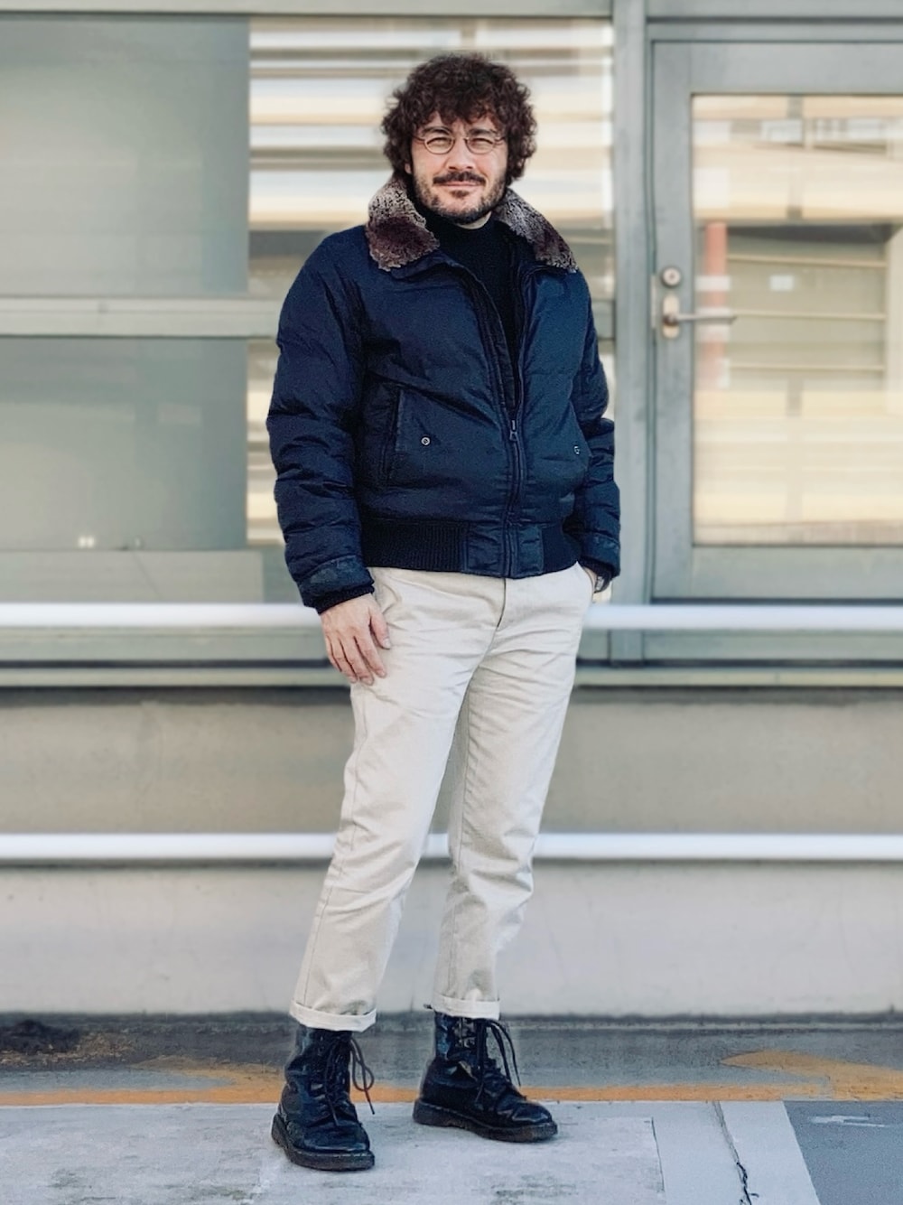 ブラック系のダウンジャケット/コート、ベージュ系のチノパンツ、ブラック系のブーツを着用したメンズの冬コーディネートの1枚目の写真