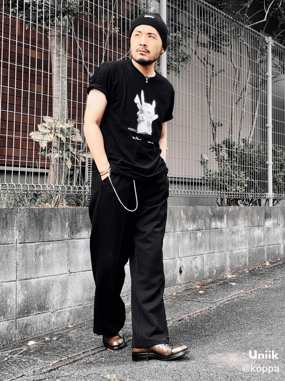 ブラック系のTシャツ/カットソー、ブラック系のスラックス、グリーン系のブーツを着用したメンズの秋コーディネートの1枚目の写真