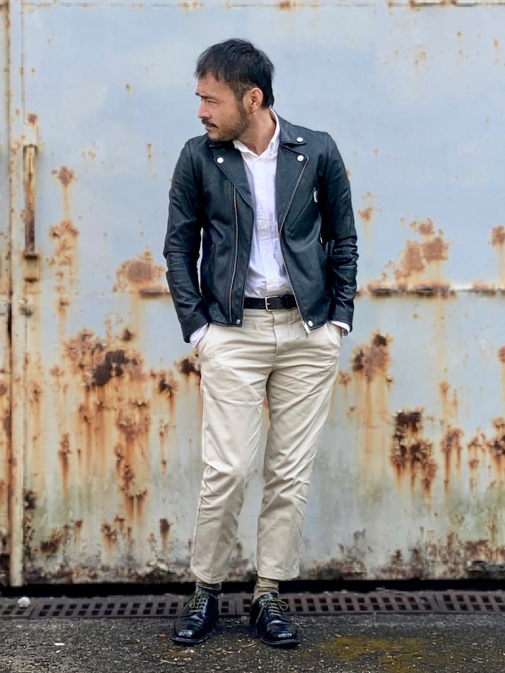 ホワイト系のシャツ/ブラウス、ブラック系のライダースジャケット、ベージュ系のチノパンツを着用したメンズの冬コーディネートの1枚目の写真