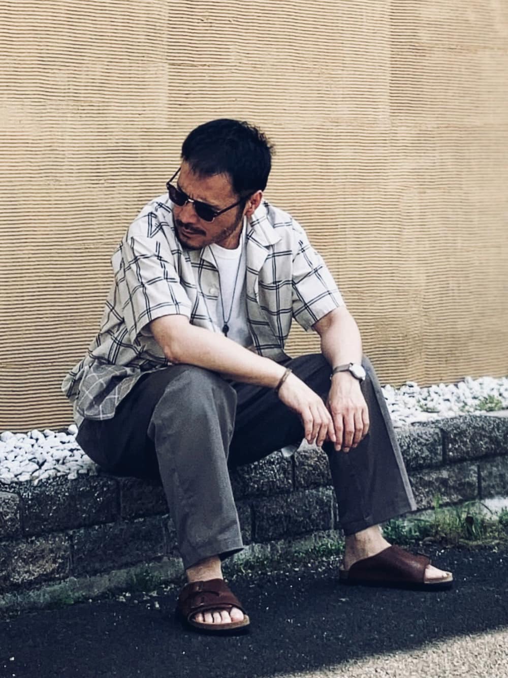 ベージュ系のシャツ/ブラウス、ホワイト系のTシャツ/カットソー、グレー系のスラックスを着用したメンズの春コーディネートの1枚目の写真