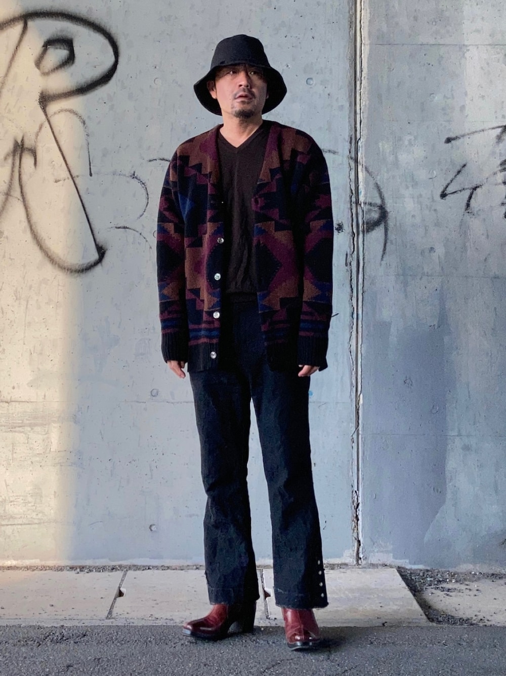 ブラック系のカーディガン/ボレロ、ブラウン系のニット/セーター、ブラック系のその他パンツを着用したメンズの秋コーディネートの1枚目の写真