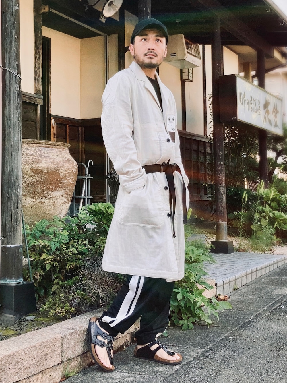 ブラック系のTシャツ/カットソー、ホワイト系のダウンジャケット/コート、ブラック系のその他パンツを着用したメンズの秋コーディネートの1枚目の写真