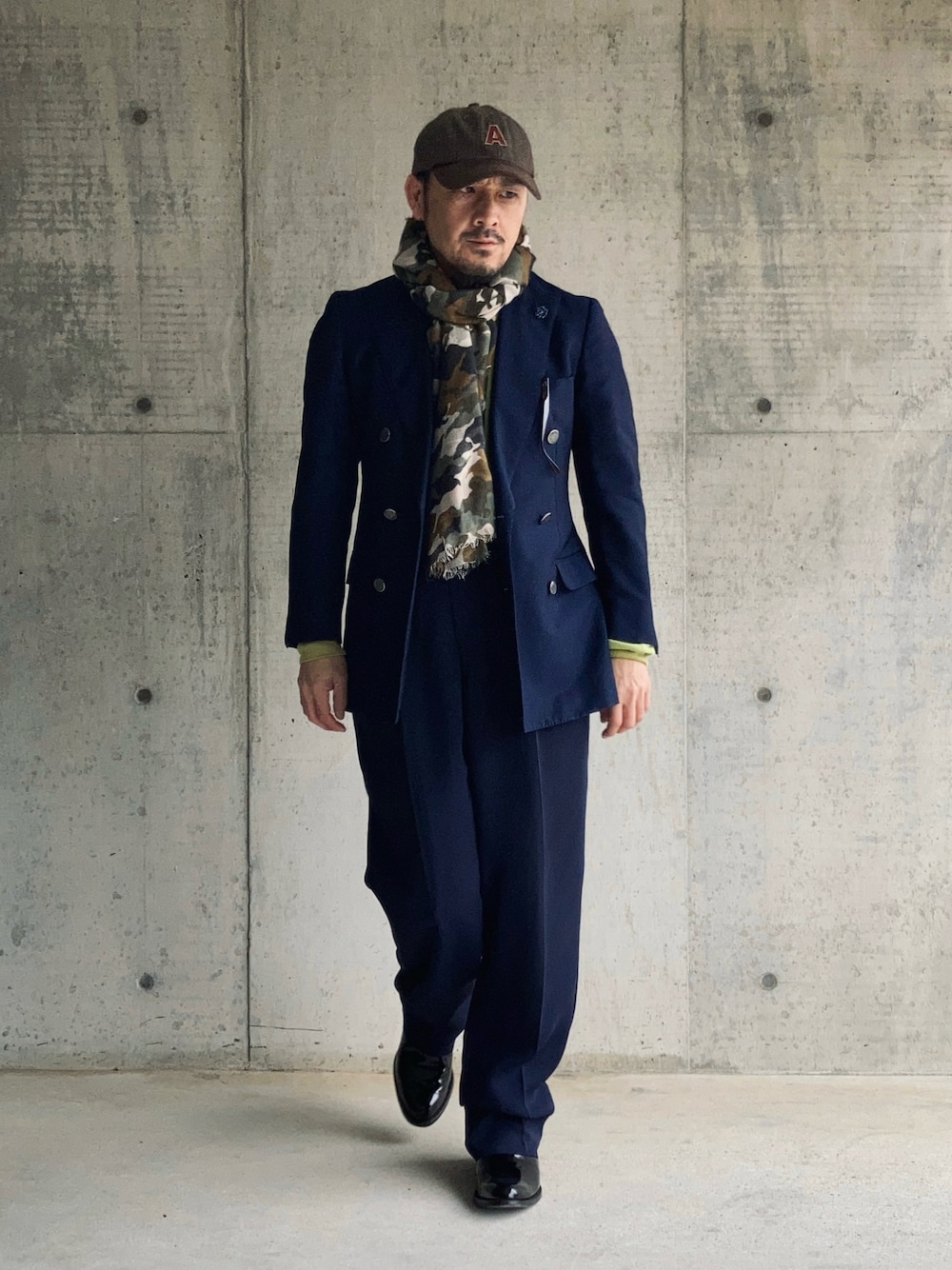 ブルー系のテーラードジャケット、ブルー系のスラックス、グリーン系のポロシャツを着用したメンズの冬コーディネートの1枚目の写真