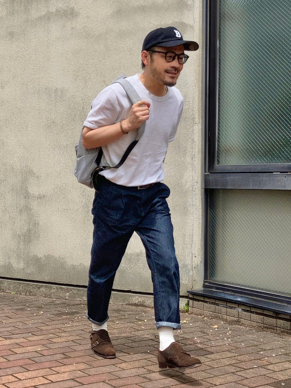 ホワイト系のTシャツ/カットソー、ブルー系のデニムパンツ、ブラウン系のドレスシューズを着用したメンズの春コーディネートの1枚目の写真