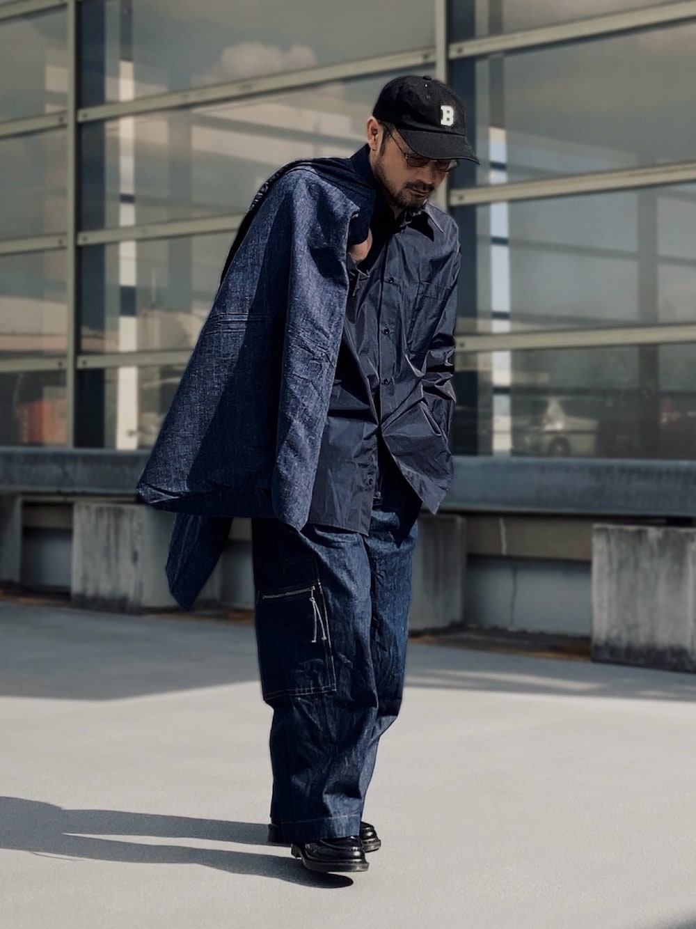 ブラック系のシャツ/ブラウス、ブルー系のデニムパンツ、ブラック系のローファーを着用したメンズの冬コーディネートの1枚目の写真