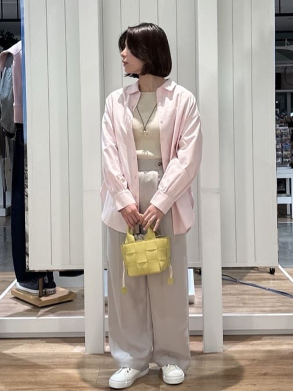 ピンク系のシャツ/ブラウス、ホワイト系のニット/セーター、ベージュ系のその他パンツを着用したレディースの春コーディネートの1枚目の写真