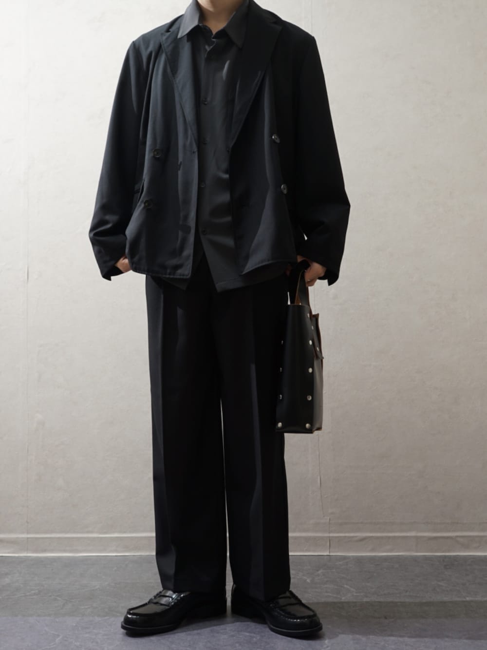 ブラック系のテーラードジャケット、ブラック系のスラックス、グレー系のシャツ/ブラウスを着用したメンズの冬コーディネートの1枚目の写真