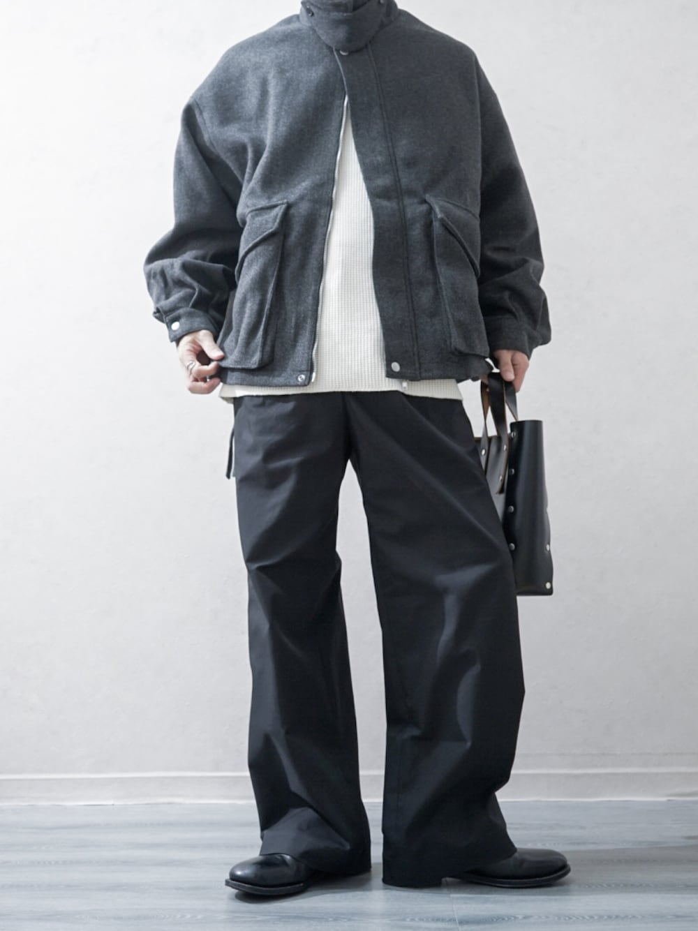 グレー系のブルゾン、ホワイト系のTシャツ/カットソー、ブラック系のその他パンツを着用したメンズの秋コーディネートの1枚目の写真