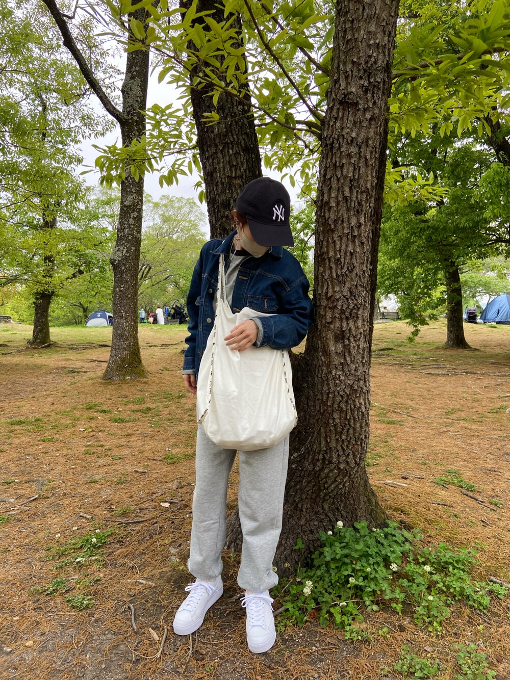 ブルー系のデニムジャケット、グレー系のスウェットパンツ、ホワイト系のスニーカーを着用したレディースの春コーディネートの1枚目の写真