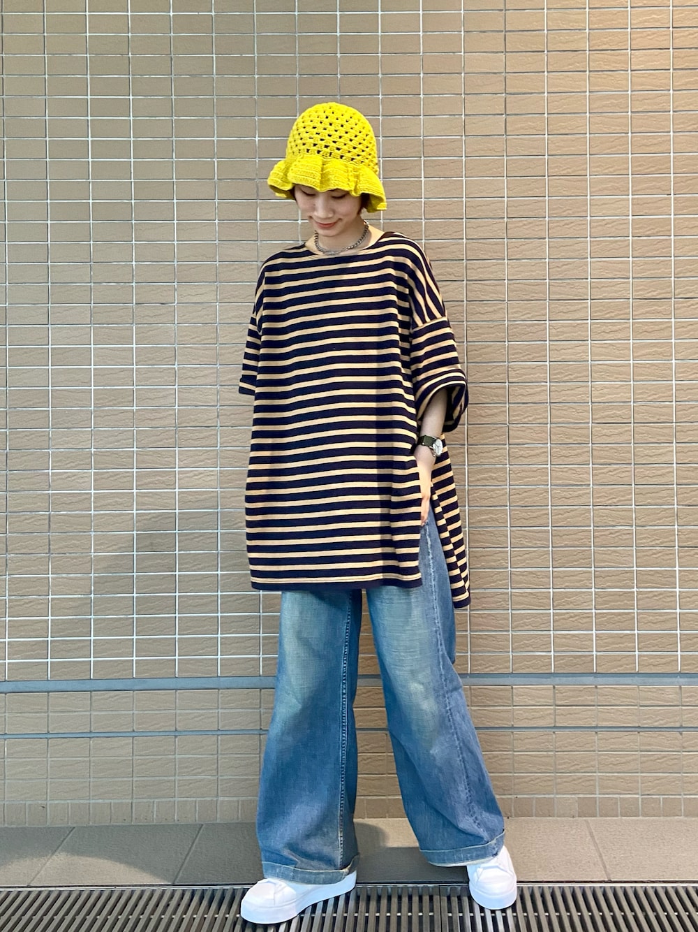 ブラウン系のTシャツ/カットソー、ブルー系のデニムパンツ、ホワイト系のスニーカーを着用したレディースの春コーディネートの1枚目の写真