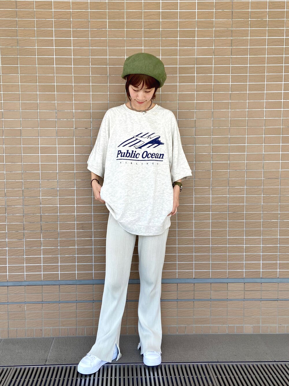 ベージュ系のTシャツ/カットソー、ベージュ系のスラックス、ホワイト系のスニーカーを着用したレディースの夏コーディネートの1枚目の写真