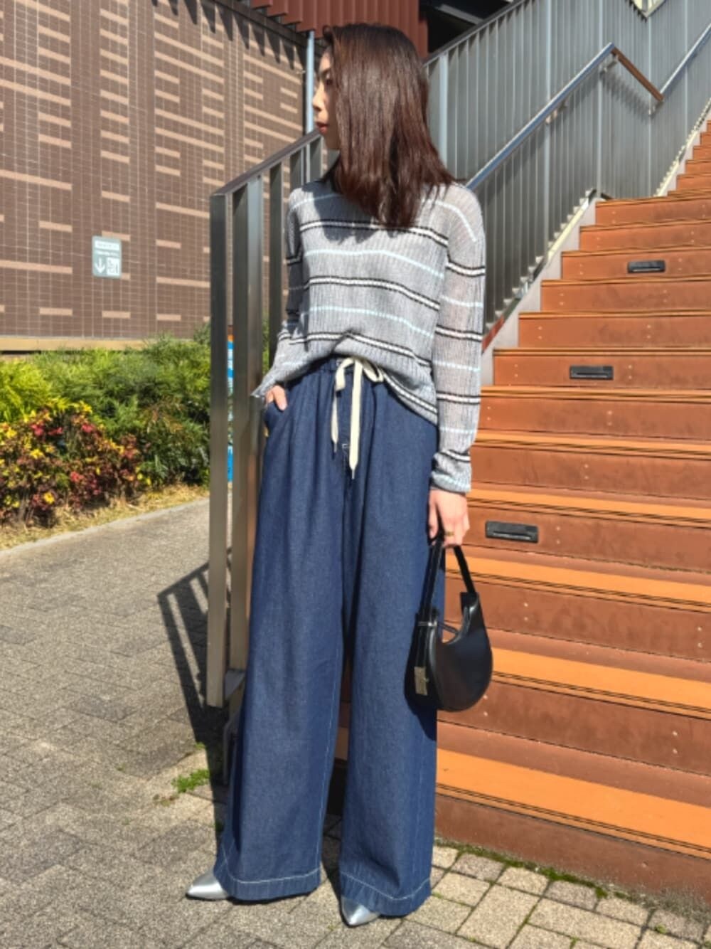 ブルー系のデニムパンツ、グレー系のニット/セーター、ブルー系のパンツを着用したレディースの春コーディネートの1枚目の写真