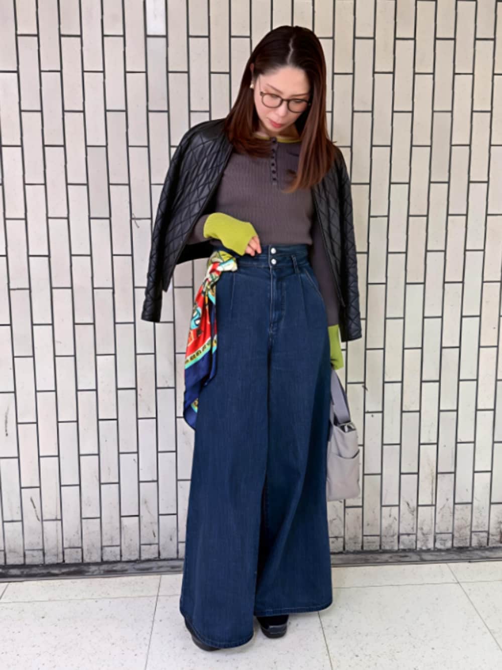 ブルー系のデニムパンツ、グレー系のニット/セーターを着用したレディースの春コーディネートの1枚目の写真