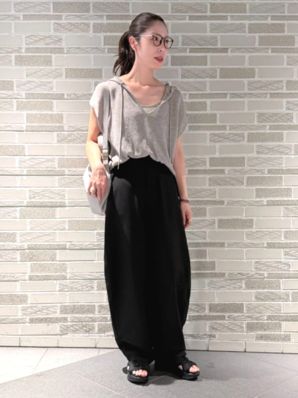 ブラック系のその他パンツ、ブラック系のパンツ、ベージュ系のニット/セーターを着用したレディースの夏コーディネートの1枚目の写真