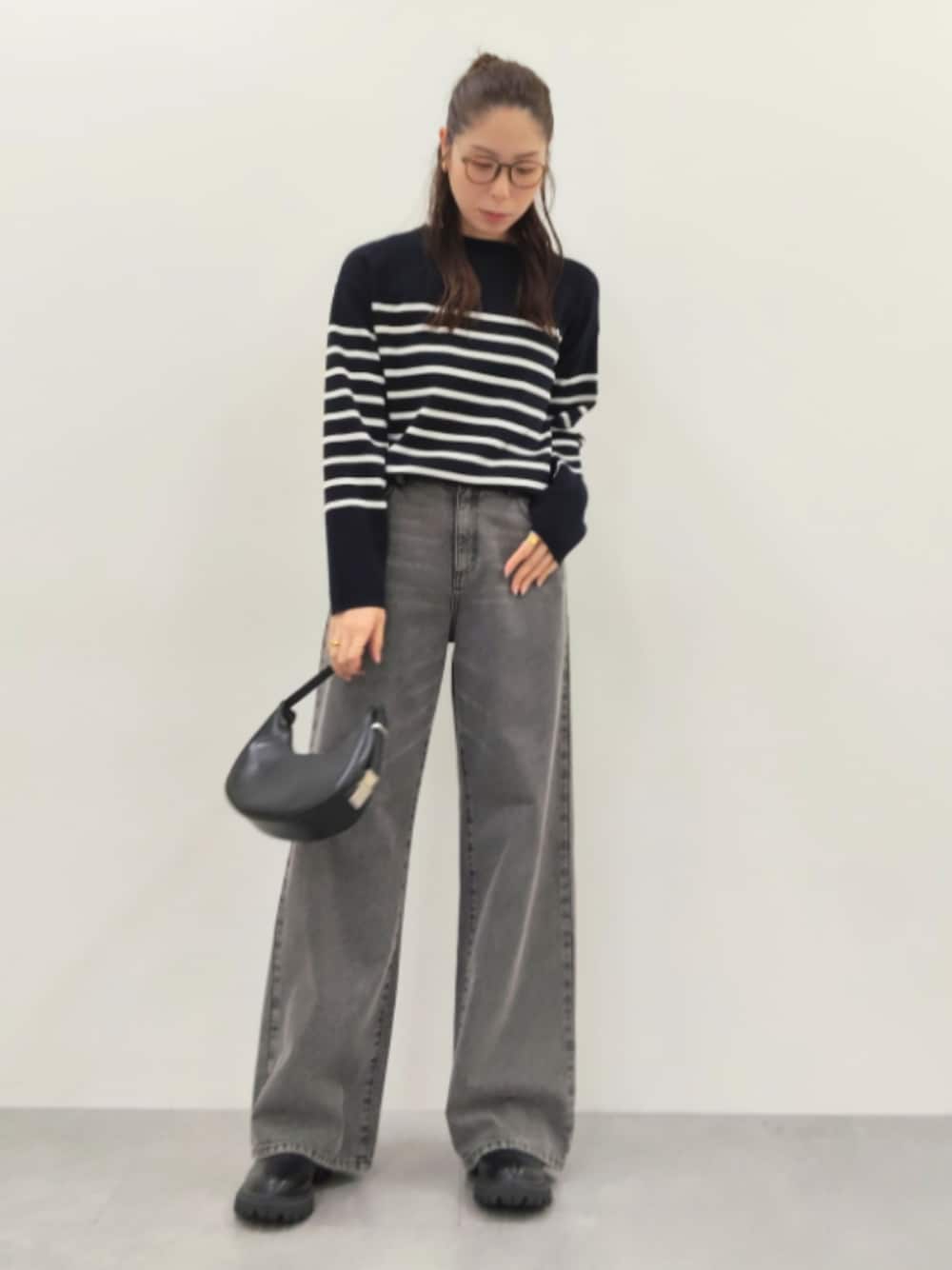 ブラック系のパンツ、ブラック系のデニムパンツ、ブルー系のニット/セーターを着用したレディースの夏コーディネートの1枚目の写真