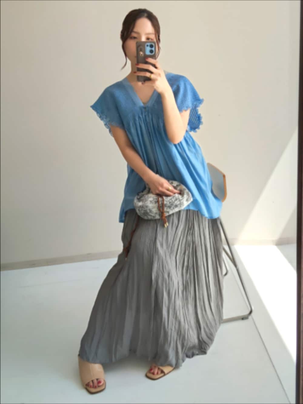 グレー系のスカート、ブルー系のシャツ/ブラウスを着用したレディースの夏コーディネートの1枚目の写真