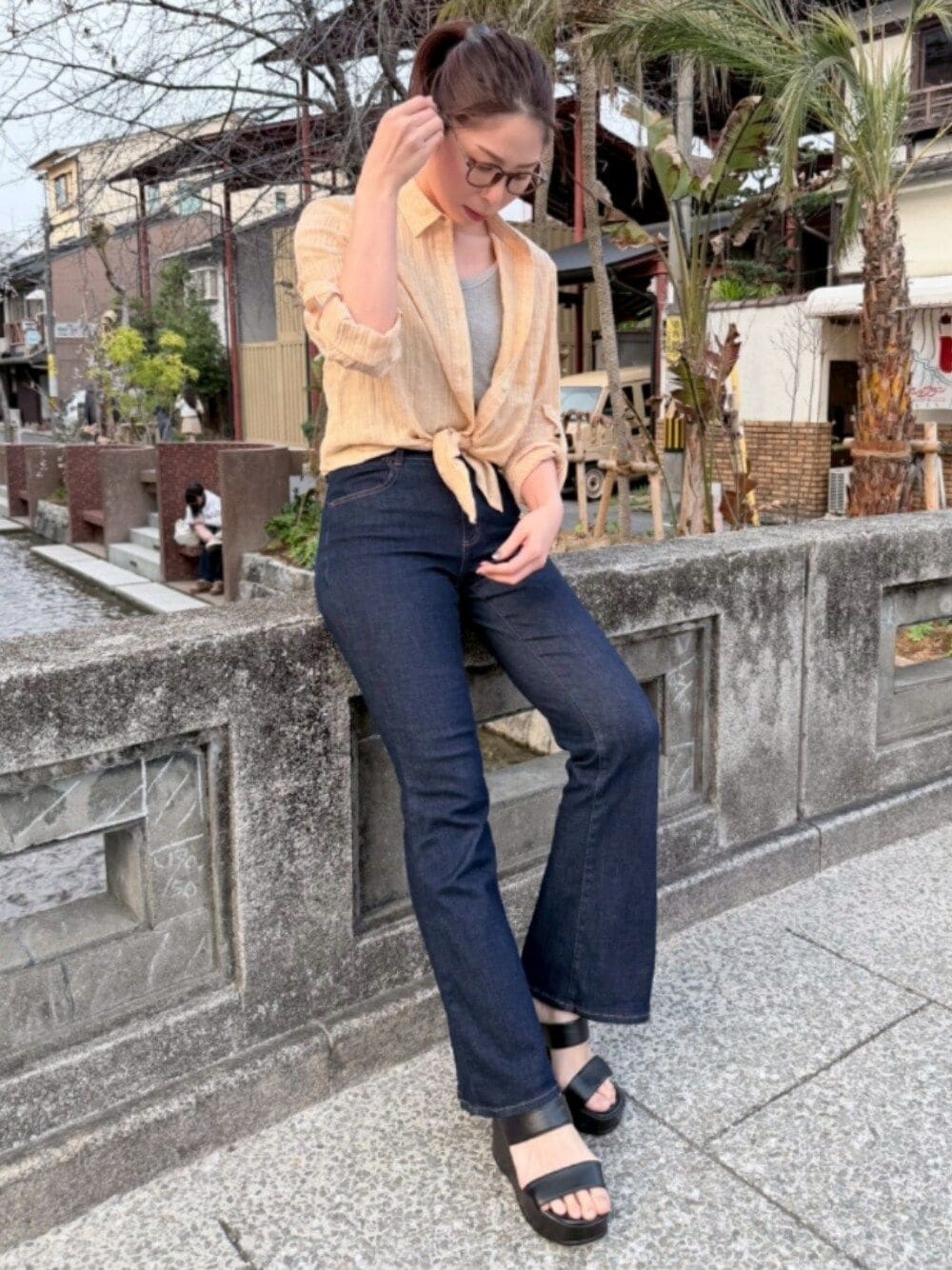 イエロー系のシャツ/ブラウス、グレー系のTシャツ/カットソー、ブルー系のデニムパンツを着用したレディースの春コーディネートの1枚目の写真