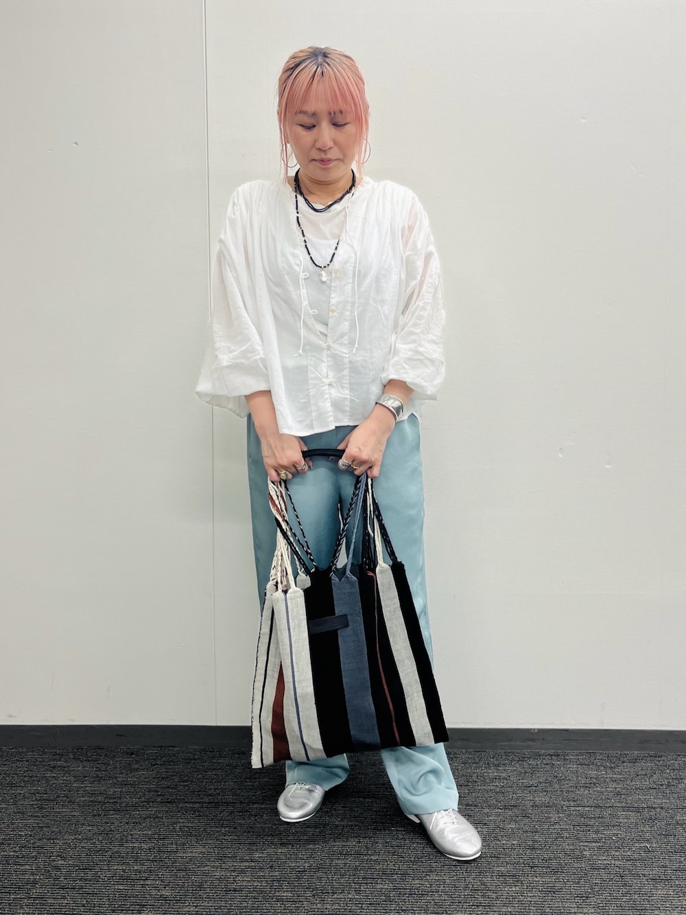 グレー系のかごバッグ、ホワイト系のシャツ/ブラウス、グリーン系のその他パンツを着用したレディースの春コーディネートの1枚目の写真