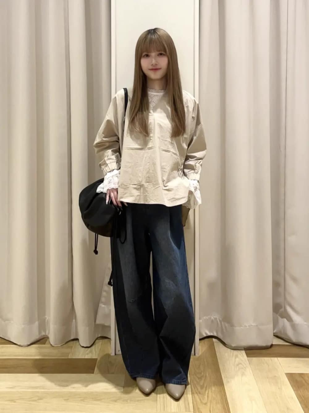 ブラック系のショルダーバッグ、ベージュ系のシャツ/ブラウス、ホワイト系のTシャツ/カットソーを着用したレディースの春コーディネートの1枚目の写真