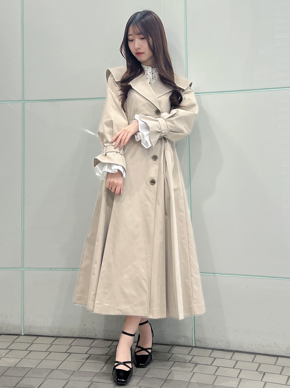 ベージュ系のトレンチコート、ブラック系のサンダルを着用したレディースの冬コーディネートの1枚目の写真