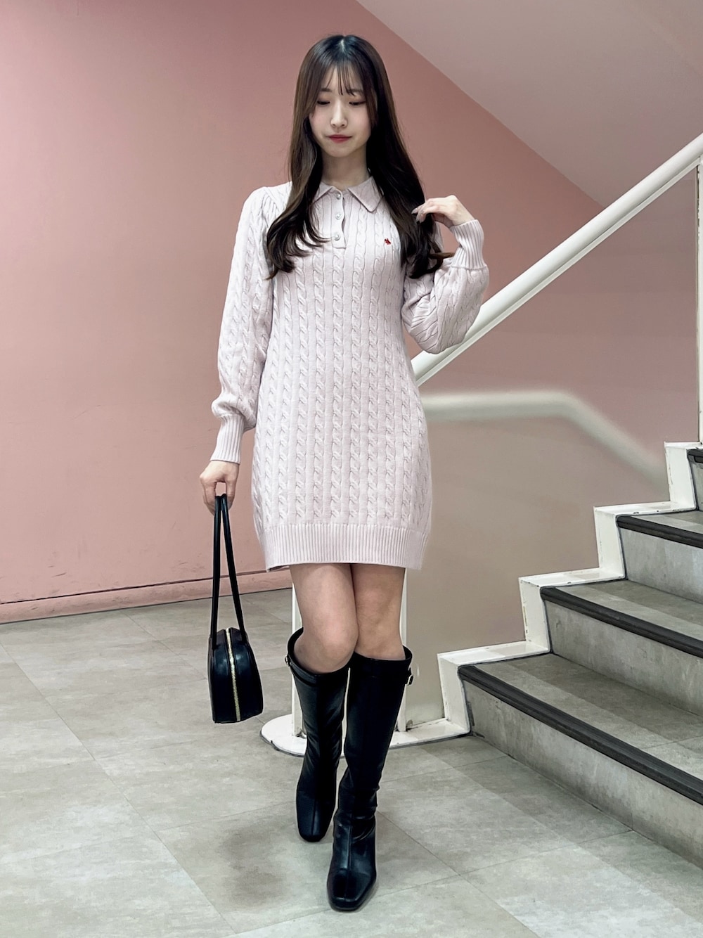 ピンク系のワンピース、ブラック系のブーツ、ブラック系のハンドバッグを着用したレディースの秋コーディネートの1枚目の写真