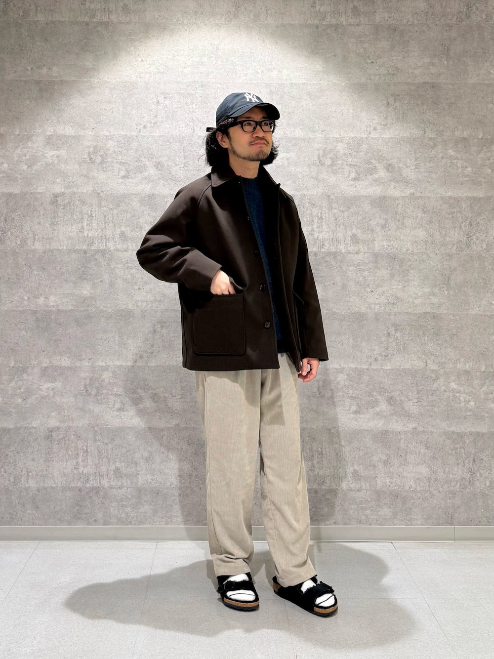 ブラウン系のその他アウター、グリーン系のニット/セーター、ベージュ系のその他パンツを着用したメンズの秋コーディネートの1枚目の写真