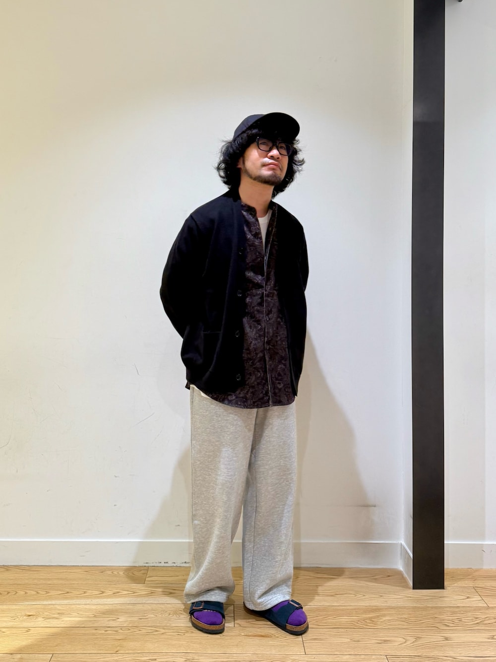 ブラック系のカーディガン/ボレロ、ホワイト系のTシャツ/カットソー、ブラウン系のシャツ/ブラウスを着用したメンズの秋コーディネートの1枚目の写真