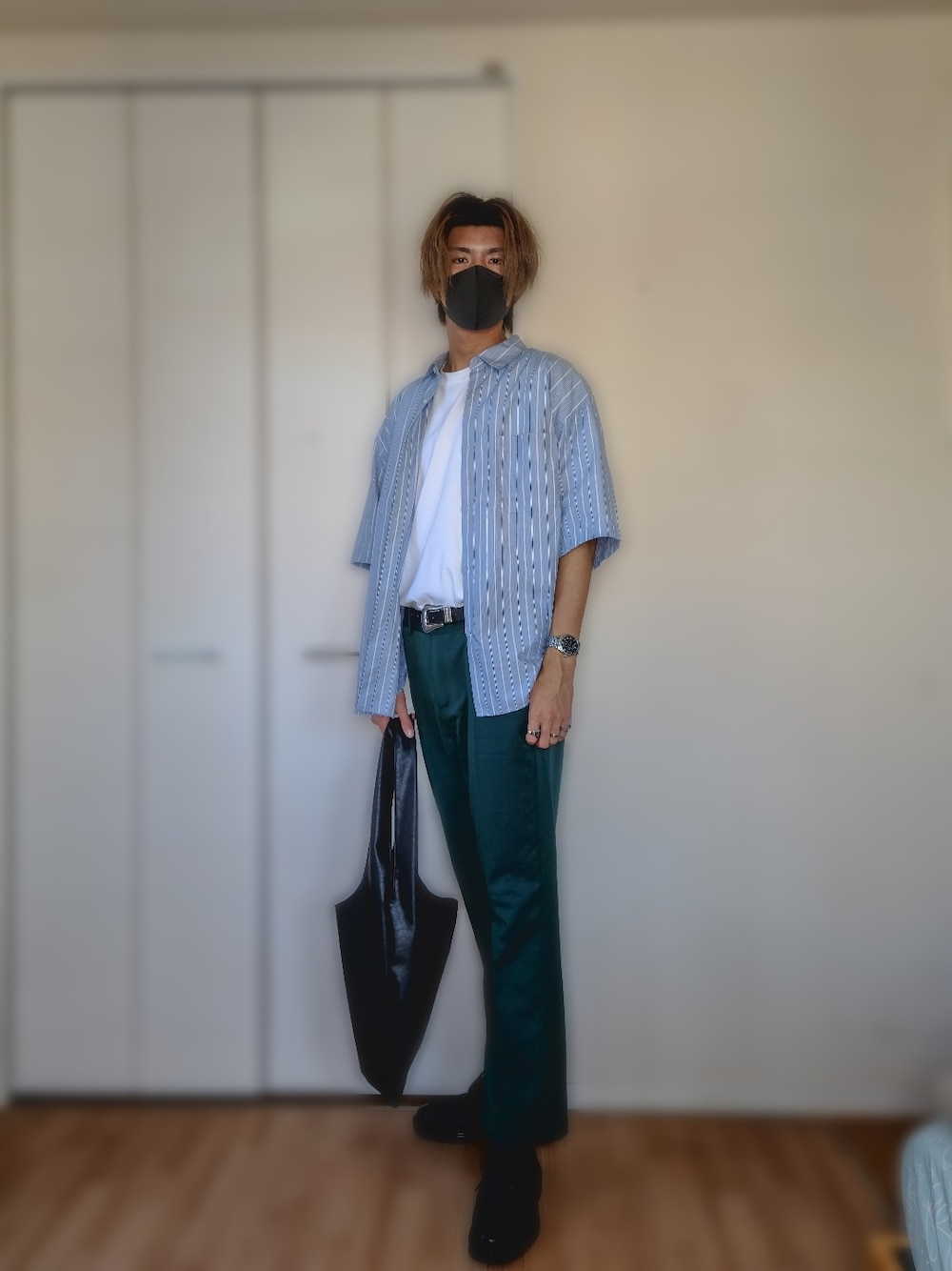 グリーン系のスラックス、ブラック系のトートバッグ、ブラック系のドレスシューズを着用したメンズの秋コーディネートの1枚目の写真