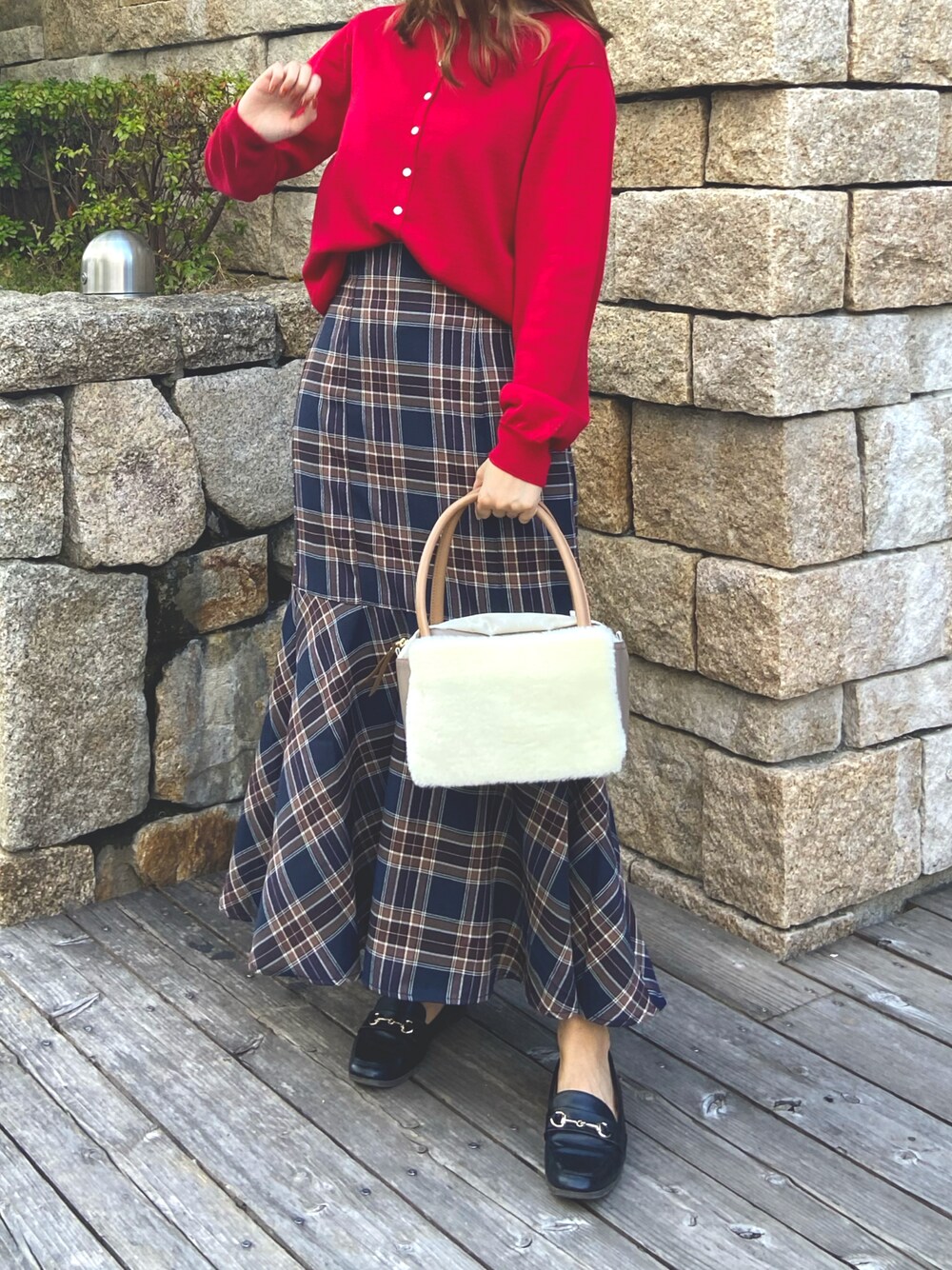 レッド系のカーディガン/ボレロ、ホワイト系のボストンバッグ、ブルー系のスカートを着用したレディースの秋コーディネートの1枚目の写真