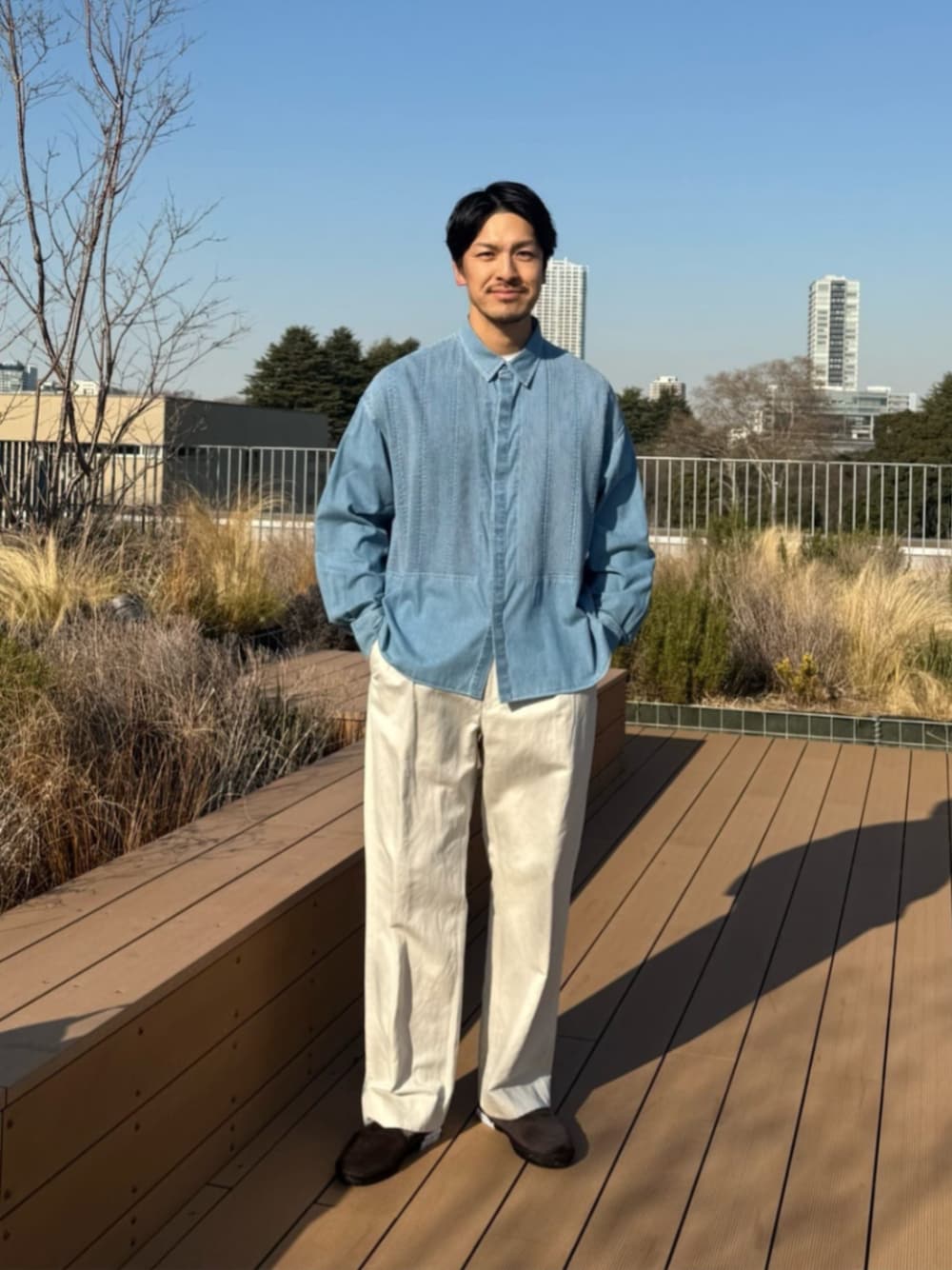 ブルー系のシャツ/ブラウス、ベージュ系のチノパンツを着用したメンズの春コーディネートの1枚目の写真