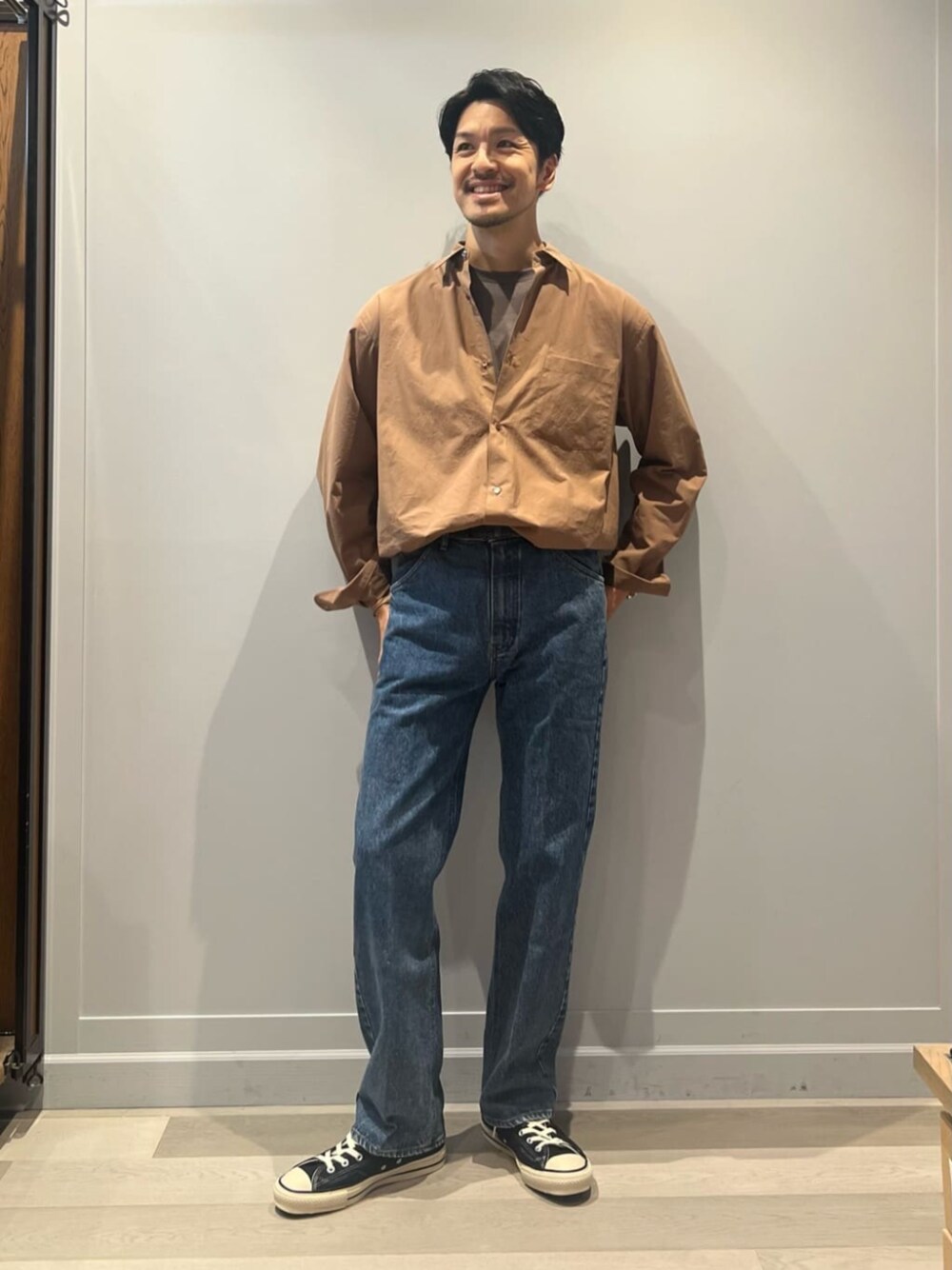 ブラウン系のシャツ/ブラウス、ブルー系のデニムパンツ、ブルー系のスニーカーを着用したメンズの秋コーディネートの1枚目の写真