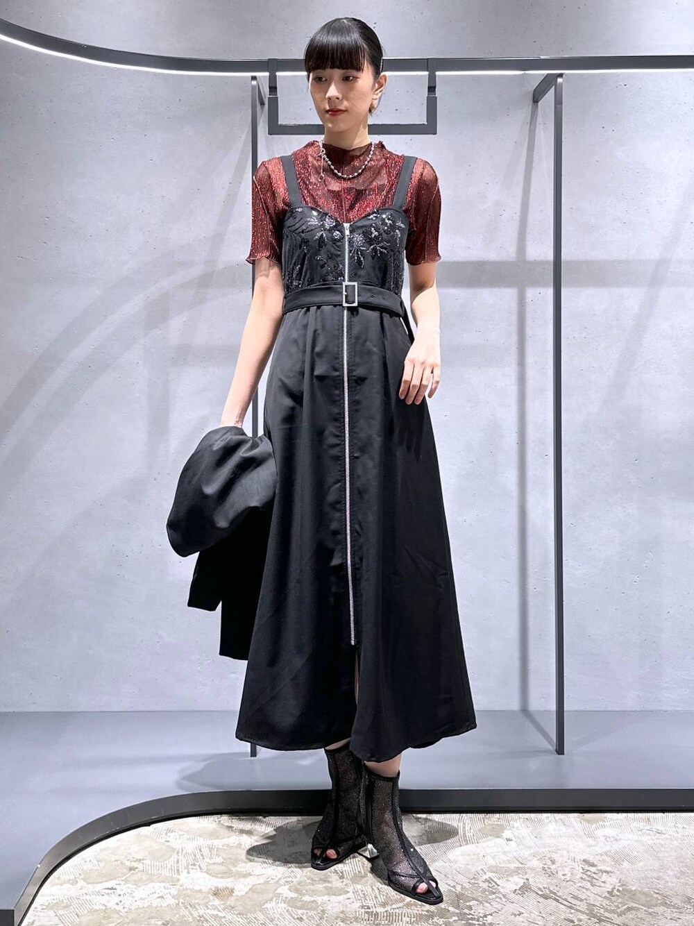 ブラック系のサンダル、レッド系のTシャツ/カットソー、ブラック系のジャンパースカートを着用したレディースの夏コーディネートの1枚目の写真