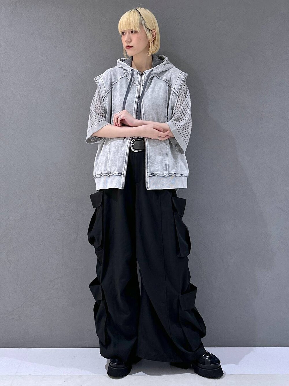 ブラック系のサンダル、ブラック系のカーゴパンツ、グレー系のニット/セーターを着用したレディースの春コーディネートの1枚目の写真