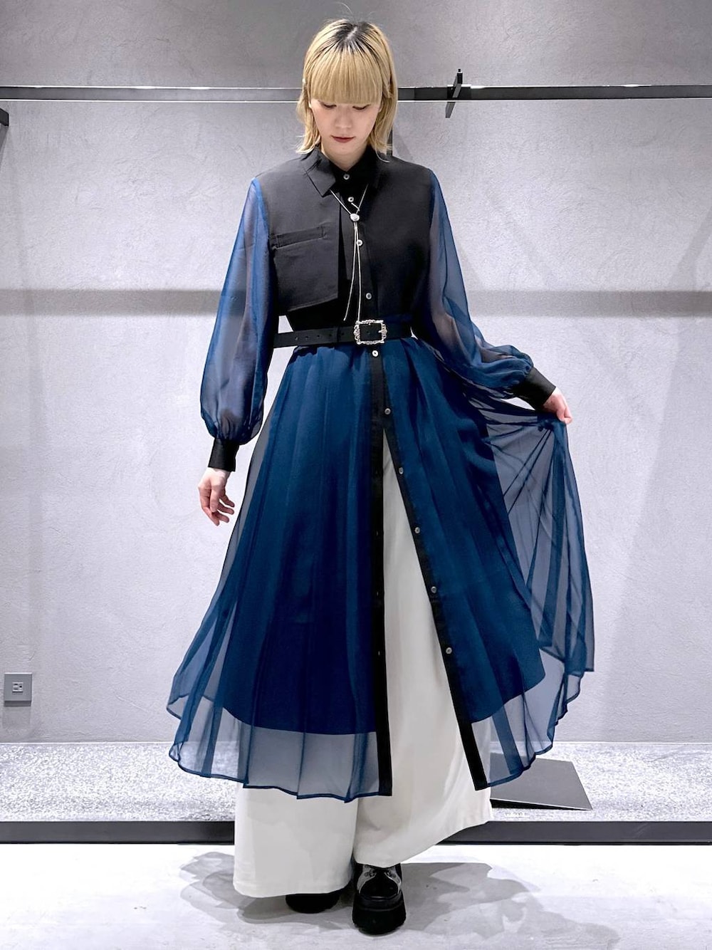 シルバー系のサンダル、ブラック系のワンピース、ホワイト系のスラックスを着用したレディースの春コーディネートの1枚目の写真