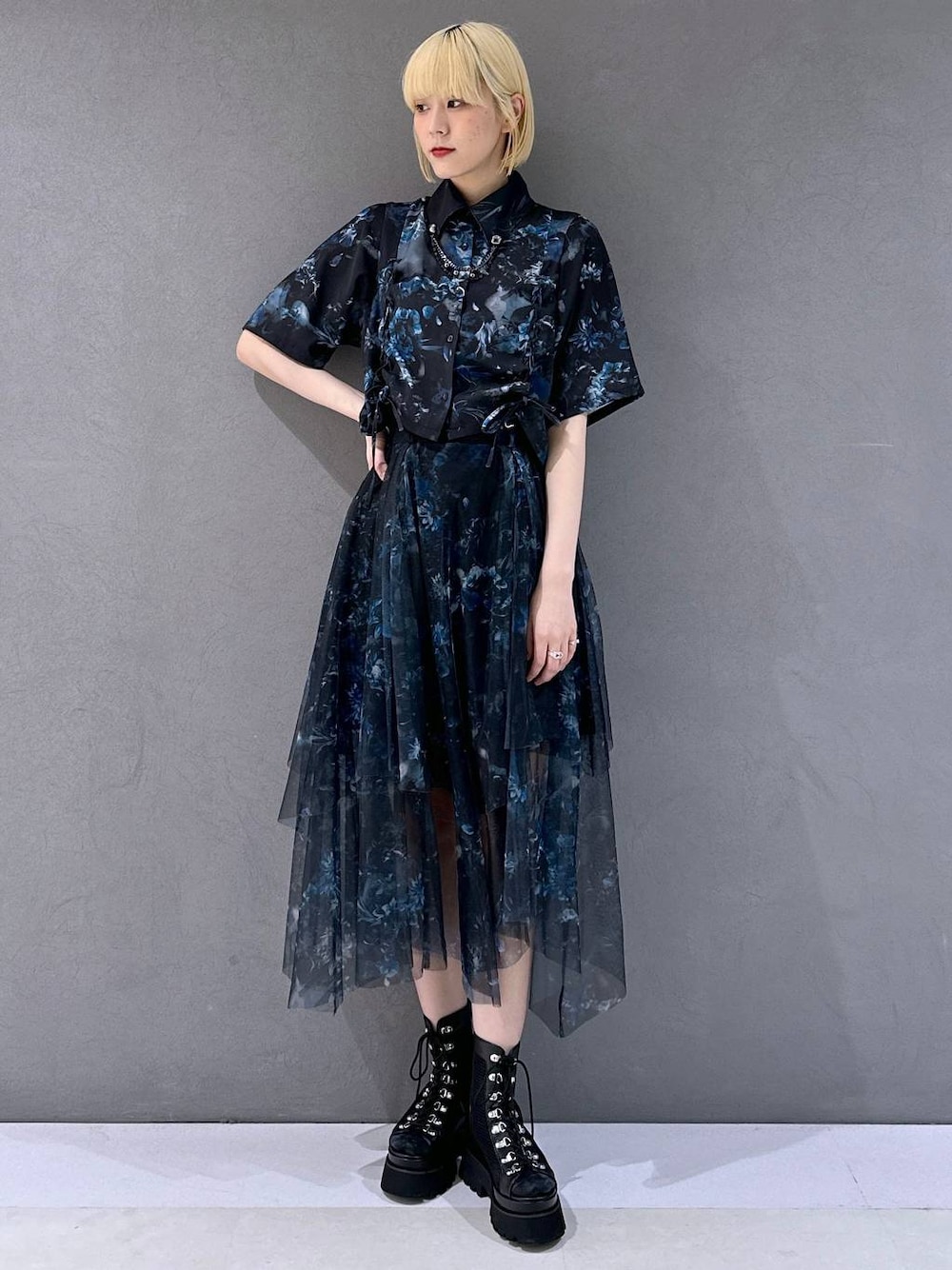 ブラック系のサンダル、ブルー系のシャツ/ブラウス、ブラック系のブローチ/コサージュを着用したレディースの春コーディネートの1枚目の写真