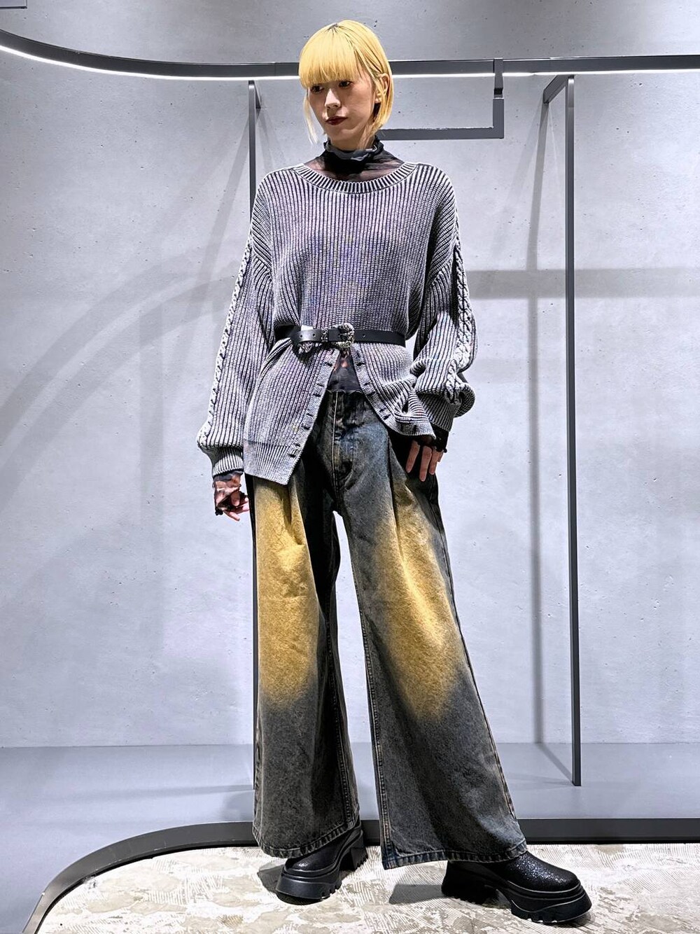 オレンジ系のデニムパンツ、ブラック系のブーツ、オレンジ系のTシャツ/カットソーを着用したレディースの秋コーディネートの1枚目の写真