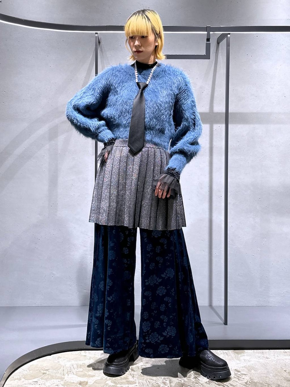 ブラック系のネクタイ、ブルー系のニット/セーター、ブラック系のTシャツ/カットソーを着用したレディースの冬コーディネートの1枚目の写真