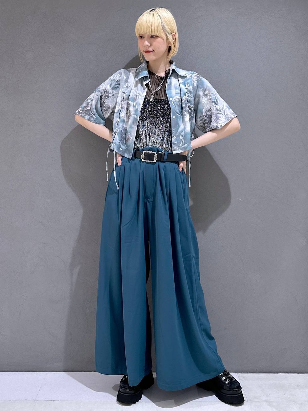 ブラック系のサンダル、ブルー系のスラックス、ブラック系のTシャツ/カットソーを着用したレディースの春コーディネートの1枚目の写真