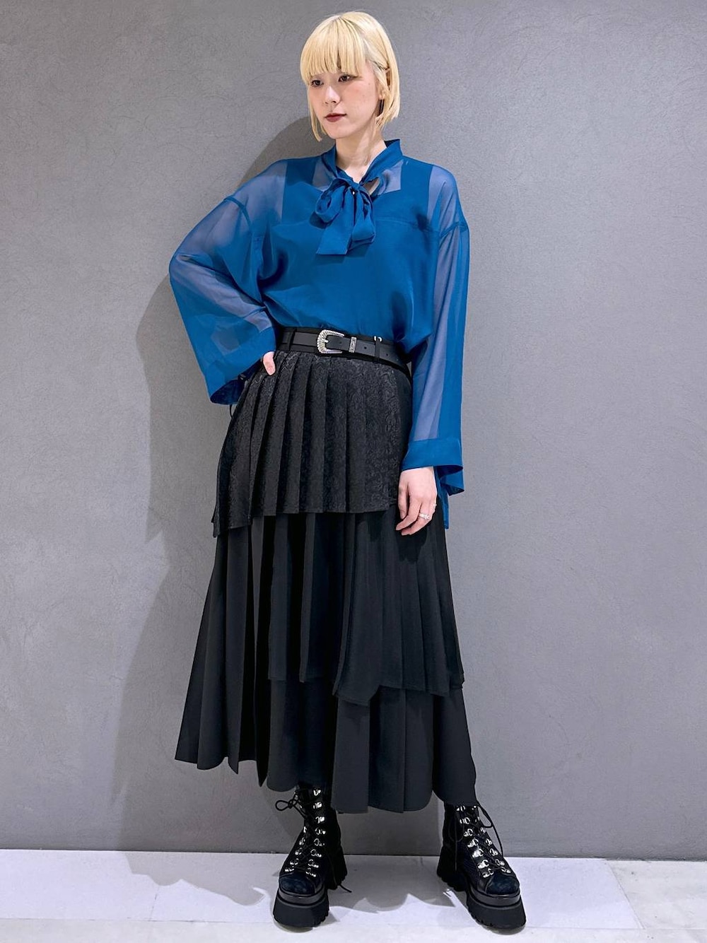 ブラック系のサンダル、ブラック系のスカート、ブルー系のTシャツ/カットソーを着用したレディースの春コーディネートの1枚目の写真