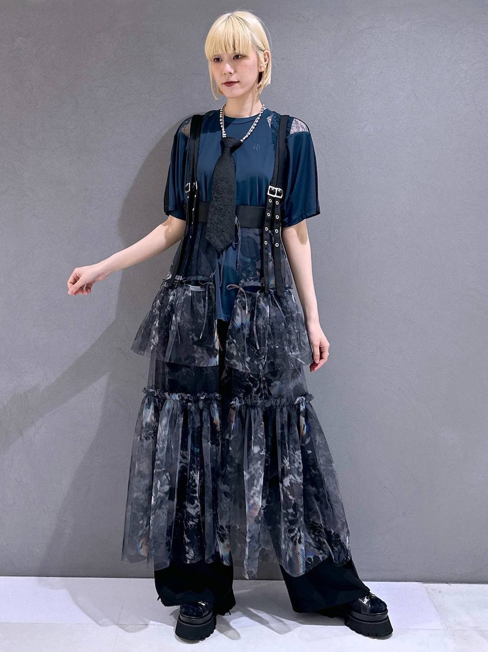 ブラック系のネクタイ、ブラック系のサンダル、グレー系のスカートを着用したレディースの春コーディネートの1枚目の写真