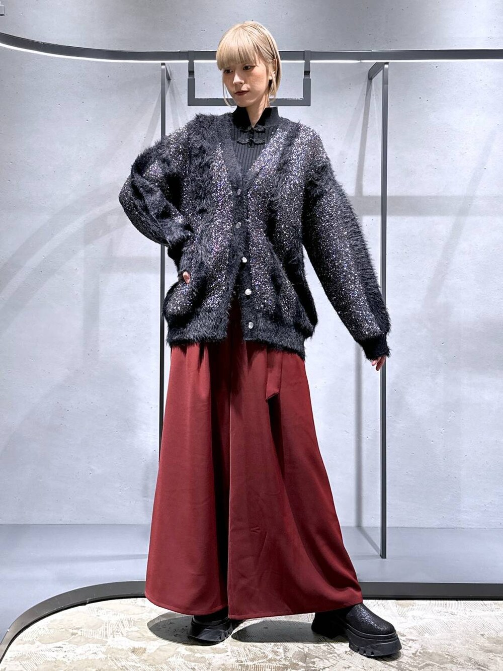 レッド系のその他パンツ、ブラック系のブーツ、ブラック系のニット/セーターを着用したレディースの冬コーディネートの1枚目の写真