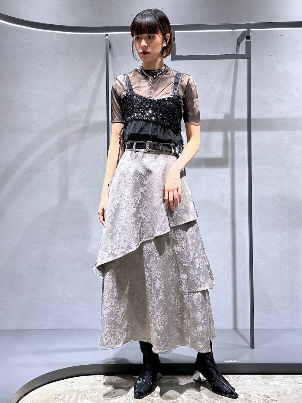 ブラック系のサンダル、ブラック系のチューブトップ、グレー系のスカートを着用したレディースの夏コーディネートの1枚目の写真