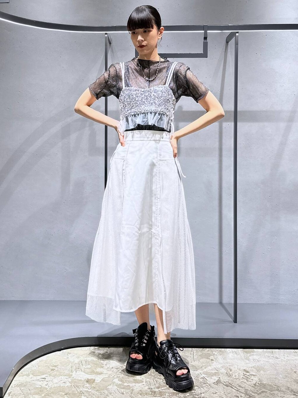 シルバー系のチューブトップ、ブラック系のTシャツ/カットソー、ホワイト系のスカートを着用したレディースの夏コーディネートの1枚目の写真